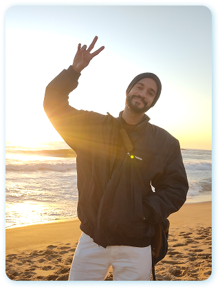 William na praia, fazendo sinal de dois dedos, durante viagem ao Chile em 2022